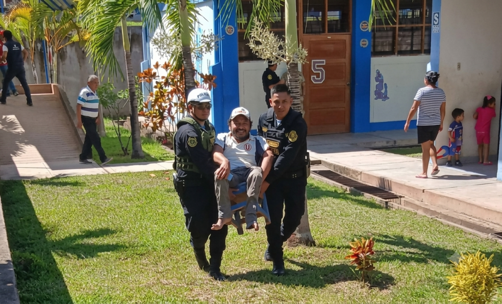 Policías cargan en silla de madera a elector con discapacidad para que pueda ejercer su derecho al voto